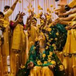 Arjun Kamath Instagram - Memories from a day when the sun came down to play with us. 💛 Nidhi's glorious wedding ceremony was preceded by the most jovial and colourful haldi celebration. The morning was still young and fresh at the Heritage Khirasara Palace of Rajkot. The family was painted in a bright and inciting yellow for the haldi, bringing the scene to life with a riot of colours and celebration. As I walked the vibrant space, I was glad to observe the mirth that filled the air along with all the sparkle and gold. The ladies sang folk songs and danced in circles, the kids played catch in all their liveliness, and Nidhi, laced in grace and charm, was taking in each precious moment as felicity unfurled around her. To my delight, these pictures reflect the pure joy that filled the room that morning. Each moment bursted with colour and energy, and I was grateful to revel in its glory as I froze those precious emotions in time. Today, when I see these photographs, I can't help but transport myself back to that sprightly morning and feel the bliss I felt then all over again. Nidhi+Shirish, February 2022 #CapturedOnCanon with a @canonindia_official EOS R5 with a CanonRF 24-70 f/2.8 L USM #weddinng #weddingphotography #weddingphotographer #weddingflowers #haldiceremony #haldi #indianwedding #arjunkamathphotography #rajkot #DoGreatWithCanon #MentorsInFocus #EOSMaestro #instagood #instagram