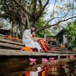 Arjun Kamath Instagram - Unbound laughter, graceful moments of love, and the sublime beauty of nature. I had the perfect elixir to craft the prewedding portraits of Sharadh and Sharayu, two jovial folks who could light up any room they walked into. The gentle morning sun was by our side as we strolled the verdant milieus of Tamarind Tree, Bengaluru. Whiffs of crisp air enchanted us, fragrant with the scent of fresh flowers and mud. Accompanying us were tiny colourful birds and the golden rays of the sun, as we explored the little green pockets of serenity around us. That morning, Sharadh and Sharayu had arrived in an adorable lighthearted spirit. Their traditional attires of red and white complemented the earthy tones of Tamarind Tree, and their radiant smiles did the rest of the trick. We spent the next few hours immersed in sweet laughter and love, as I pictured them in all their beauty and grace. I still remember the precious look in their eyes and the warmth they shared with each other. Perhaps that gives these photographs the special place they have in my heart. That I collected all the love, light, and laughter from those moments and gave them to the couple to cherish forever. #CapturedOnCanon with a @canonindia_official EOS R5 with a CanonRF 24-70 f/2.8 L USM #preweddingshoot #indian #couple #love #laughter #preweddingphotography #prewedding #indianwear #indianphotography #indianfashion #saree #sareelove #flowers #sunrise #arjunkamathphotography #bangalore #DoGreatWithCanon #MentorsInFocus #EOSMaestro #instagood #instagram The Tamarind Tree
