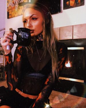 Daisy Coleman Instagram - What’s better than curling up next to the fireplace with a mug of hot coco while it’s snowing? 
The answer is curling up next to the fireplace with a mug of coco that I can smoke out of in my new socks from @inkedmag 😍 I think I might need five more of these because they’re just so perfect for the Holliday’s and stocking stuffers 🎅🏼🎄❄️❤️💚 #inkedholliday #inkedshop 
Use my code YOUNGCATTATTOOSINKEDHOLIDAY and link https://glnk.io/4y9/youngcattattoosinked to get a special discount 😍💚❤️