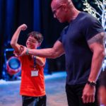 Dwayne Johnson Instagram – Already more muscles than me – just another day in the life of Peyton Frederick from @makeawishamerica. 😉💪🏾

He’s 10 and he’s awesome! 

Peyton’s wish was to meet me. 

And man this kid lights up the room with his awesome personality!! 

Loves playing sports and already establishing those building blocks of discipline of the hardest workers in the room. 

He was proud to let me know he had gotten his morning workout in before we met 😄👏🏾💪🏾

We had a lot of laughs together and I was very impressed with this kid. He could go on to become a pro athlete one day and I just hope he gives me free tickets 🎟️ 🤣 

A lot of negative noise out there in the world, but there’s also a lot of amazing positive things too, and Peyton is one of them! 

#MakeAWishDay
#21Kids 
#BestDayEver