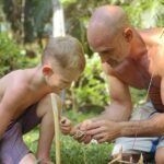 Ed Stafford Instagram - It’s good to be home 🥰. Don’t get me wrong I love my job - but nothing in the world compares to this. Ran has watched every episode of the original Marooned series since I’ve been in Africa and is now addicted to making cordage and setting traps 🪤. Don’t worry Costa Rica - no animals we harmed in the making of this post! 🤣 #traps #snares #survival #daddytime