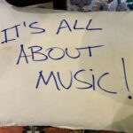 Felipe Simas Instagram - Cresci nos anos 80 e a cultura de bandas faz parte da minha formação musical, cultural, social e lúdica. Vivi Blitz, Kid Abelha, Barão, Paralamas, Titãs, Legião e tantas outras hoje representadas por ‘Jovens’ como os da foto (os Dionísios), assim como por Lagum, Hotelo, Daparte e O Grilo. Banda é caldeirão! Banda é combustão! Em 21 de maio do ano passado, os Jovens Dionísios (“como é o plural de uma banda com o nome de um único indivíduo”, Gita?) emplacaram um mega hit no topo das paradas. Coincidentemente ou não, nesse mesmo dia abriam o festival Coolritiba jogando em casa na lendária Pedreira Paulo Leminski. Enquanto faziam o show, a notícia de que ‘Acorda Pedrinho’ era número 1 já corria o Brasil. Eu assistia da coxia (as Anavitória entrariam em seguida) quando meu telefone tocou com um inusitado convite para que eles se apresentassem no programa Domingo Legal. Soava quase como uma fenda no espaço-tempo: Uma banda estourando um hit e fazendo playback no SBT! Um tanto inusitado pros dias de hoje, mas seria absurdamente normal nos anos 90. Transmiti na mesma hora o convite ao empresário Enricco Pasquali que topou sem titubear. Contratamos uma van e embarcamos no meio da madrugada pro CDT da Anhanguera, o famoso complexo de estúdios do Sistema Brasileiro de Televisão. Os poucos mais de 400 quilômetros que separam Curitiba de São Paulo foram apenas os primeiros de milhares de outros que eles rodaram a partir de então. Fizeram shows por todo o país e ganharam também Portugal. Até hoje ainda estão assimilando tudo o que aconteceu e dizem que a sensação é a de que um dia os colocaram numa van de onde nunca mais saíram. Em visita ao QG dos Jovens dia desses em Curitiba, eles me contaram que o travesseiro que deixei esquecido naquela van acabou virando companheiro das infindas viagens. Gentilmente recusei a devolução da confortável almofada e atendi a pronta solicitação de deixar marcado nela o lema que norteia todos os meus papos sobre estratégias de carreiras: “It’s all about music!”. Pois bem, essa van na qual eles embarcaram na madrugada do dia 22 de maio de 2022 agora levanta voo rumo a Europa. Boa Eurotour aos Jovens! Curitiba, Paraná