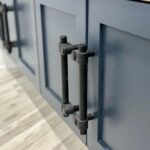 John Colaneri Instagram - My clients mudroom has been updated with custom cabinet doors and hardware. All have been painted with one of my favorites by @benjaminmoore called Mysterious AF-565 and hardware by @busterandpunch. There is a ton of storage and this color really transforms the space. The black hardware is so unique and will be a conversation starter for sure! #custommillwork #design #designinspiration #designgoals #mudroom #mudroommakeover