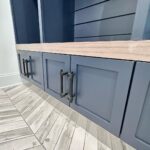 John Colaneri Instagram - My clients mudroom has been updated with custom cabinet doors and hardware. All have been painted with one of my favorites by @benjaminmoore called Mysterious AF-565 and hardware by @busterandpunch. There is a ton of storage and this color really transforms the space. The black hardware is so unique and will be a conversation starter for sure! #custommillwork #design #designinspiration #designgoals #mudroom #mudroommakeover