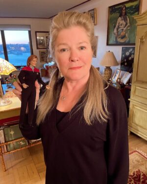 Kate Mulgrew Instagram - A cross-posted thread of photos from my Twitter:

1. Tiny Janeway from @startrekexo6 paid me a visit and caught me up on all the #StarTrek news! Everyone has been very busy.
2. She said that you all loved the new trailer for #StrangeNewWorlds, welcome to the family! Helming a series isn't for the faint of heart, but @ansonmount is up to the job.
3. A great deal of fun was had on the @startrekthecruise , which I will be part of once again in 2023. Tropical beverages may be consumed in greater quantites and I will need @robert_picardo to be ready with hangover remedies. 🍹🍹
4. Also, Star Trek Online had several ships become canon - this is applauded by both Admiral and Marshal Janeway, although my mirror counterpart gave off more of an "about time!" vibe. 🚀 Well done, @trekonlinegame & art by @thomas.marrone (apologies on cut-off photo)
5. She also says Q is back making trouble, and what's this I hear about collaborating with the Borg Queen??? 😱 That won't end well! I will keep an eye on this situation as it develops. #StarTrekPicard 
6. #StarTrekProdigy continues to do very well and it warms my heart to hear all your littles love Hologram Janeway! Keep those pics of your cadets coming! All 10 eps are now on @startrekonpplus if you need to catch up on the USS Protostar's adventures. @nickelodeon 
7. And with that, she concluded her debrief and had to head back to Starfleet HQ. Keep up the good work, Team Trek! 🖖🏻
