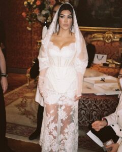 Kourtney Kardashian Barker Instagram - One year ago, we had our first in-person meeting with @dolcegabbana to start the design process of my wedding dress!! The first inspiration for my dress was when Travis and I were watching Guns N’ Roses November Rain video one night before we were even engaged, and we said to each other “this has to be our wedding.” She was wearing a short dress and I thought to myself “I need a short dress!” I had more visions inspired by some 1990s campaigns of Monica Bellucci shot by Helmut Newton for Blumarine. When we knew our wedding was going to be in Portofino, it also influenced the vibes and feeling of the dress. I also just wanted to feel like we ran off to Italy and got married and wanted the dress and wedding to feel that way! When @dolcegabbana suggested putting Travis’s head tattoo of the Virgin Mary on the handmade lace veil with the words from his tattoo: family, loyalty, respect underneath, I got chills and knew how special that felt. (And my little mini veil I wore to dinner ☺️) This was all planned and made into my dream come true all so so quickly and I’m so grateful to everyone who put their all into making it all happen! ✨🫶🏼❤️