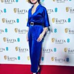 Louise Brealey Instagram – So proud of our little film. To see Brian and Charles dancing in the kitchen on the giant screen with Cate Blanchett, Viola Davis, Michelle Yeoh and Julianne Moore in the house eating chocolate BAFTA faces well that was magic.
I have a lot of people to say thank you to who made me look presentable on the red carpet. Prepare for hyperbole. It takes an army.
First. My friend and Pygmalion @mary_fellowes who spends her life now working tirelessly to make fashion more sustainable and less hideously polluting. She lent me my heavenly blue vintage velvet and assembled the crack team tasked with my transformation. Without her I would be just posting a picture of my dessert.
Hair by amazing @gillsondavid at @issysbelgravia – he is quite frankly a magician. Thank you SO much, David!
I can’t stop stroking my nails thanks to Joan (@nails.issys) they are like beautiful seashells on the ends of my funny sparrow claws.
Stylists! Magazines! Publicists! Use South African maestro @lesleywhitbymakeup – who has just decamped to London – for everything.
A massive thank-you to antique jewellers @susannahlovisjewellers who have a shop in Burlington Arcade and who trusted me with unbelievable shiny things. A gold and diamond panther bracelet from 1980 I called John. A Cartier claw ring and a star burst of diamonds in my ears. Thanks to them I thrust the panther in everyone’s face all night and no one thought I was weird.
Right I’d better get these fake eyelashes off. Happy Monday, Kids. Royal Festival Hall