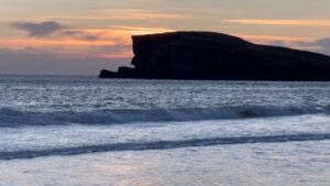Louise Brealey Instagram - We drove west along the north coast of Scotland into the dazzle of a sunset and made it to the beach just before the sun slipped down behind a band of cloud. 

There was a smushed marigold on the tide line. I walked the quarter mile to our bit of the beach, where a scree of giant pebbles meet the sand. On my phone is a picture of mum sat here with a towel on her head. 

I put the marigold on the rocks. The Mexicans call it the flower of the dead and use its bright colours to guide the spirits of their lost ones to their shrines on the Dio de los Muertos. 

I ran my fingers through the fine white sand and let the sea and the sky do their thing.