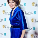 Louise Brealey Instagram – So proud of our little film. To see Brian and Charles dancing in the kitchen on the giant screen with Cate Blanchett, Viola Davis, Michelle Yeoh and Julianne Moore in the house eating chocolate BAFTA faces well that was magic.
I have a lot of people to say thank you to who made me look presentable on the red carpet. Prepare for hyperbole. It takes an army.
First. My friend and Pygmalion @mary_fellowes who spends her life now working tirelessly to make fashion more sustainable and less hideously polluting. She lent me my heavenly blue vintage velvet and assembled the crack team tasked with my transformation. Without her I would be just posting a picture of my dessert.
Hair by amazing @gillsondavid at @issysbelgravia – he is quite frankly a magician. Thank you SO much, David!
I can’t stop stroking my nails thanks to Joan (@nails.issys) they are like beautiful seashells on the ends of my funny sparrow claws.
Stylists! Magazines! Publicists! Use South African maestro @lesleywhitbymakeup – who has just decamped to London – for everything.
A massive thank-you to antique jewellers @susannahlovisjewellers who have a shop in Burlington Arcade and who trusted me with unbelievable shiny things. A gold and diamond panther bracelet from 1980 I called John. A Cartier claw ring and a star burst of diamonds in my ears. Thanks to them I thrust the panther in everyone’s face all night and no one thought I was weird.
Right I’d better get these fake eyelashes off. Happy Monday, Kids. Royal Festival Hall