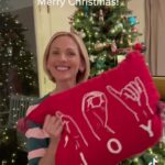 Marlee Matlin Instagram - #merrychristmas #asl #signlanguage #happyholidays Image description : Marlee Matlin signs “Merry Christmas” in American Sign Language, then pulls out a red pillow with the word JOY spelled out in ASL