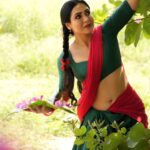 Nandini Rai Instagram – Captivating #colors and timeless elegance come #together in this stunning #image of a #woman in a vibrant #green and red sari, gracefully holding a delicate flower. The #rich #cultural heritage and #natural #beauty are #beautifully captured in this moment of serene and captivating harmony.