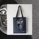 Nikhil D'Souza Instagram - Nikhil X @overapintofbeer Collaborated with these guys for 4 sets of merchandise for Shades of Grey! This tote bag is the first one, named after my sis Rhea. "Rhea – My older sister, a year senior to me, used to attend St. Xavier’s College, Mumbai. And so did I. She was the studious one and while I was loitering about the college foyer, she would have her head buried in a pile of books in the iconic wood panelled library. Bags like these were her mainstay and always will remind me of her." Buy it from the LINK in my bio, and in my story swipe up ❤️ MASSIVE thanks to @overapintofbeer for creating them and @siddhesh.sapte for designing the art. #ShadesOfGrey #mechandise #newmusic