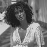 Parisa Fitz-Henley Instagram - More LA memories. Exploring shadow and light with @raziwilsonphotography 🤍🖤🩶 Post description: Three slides - black and white photos of me. A close up of me looking to camera, a medium shot of me walking, and a medium shot of me leaning back on a wall. In all I wear the same white dress and my hair is curly and shoulder length. *Reposting correct edits