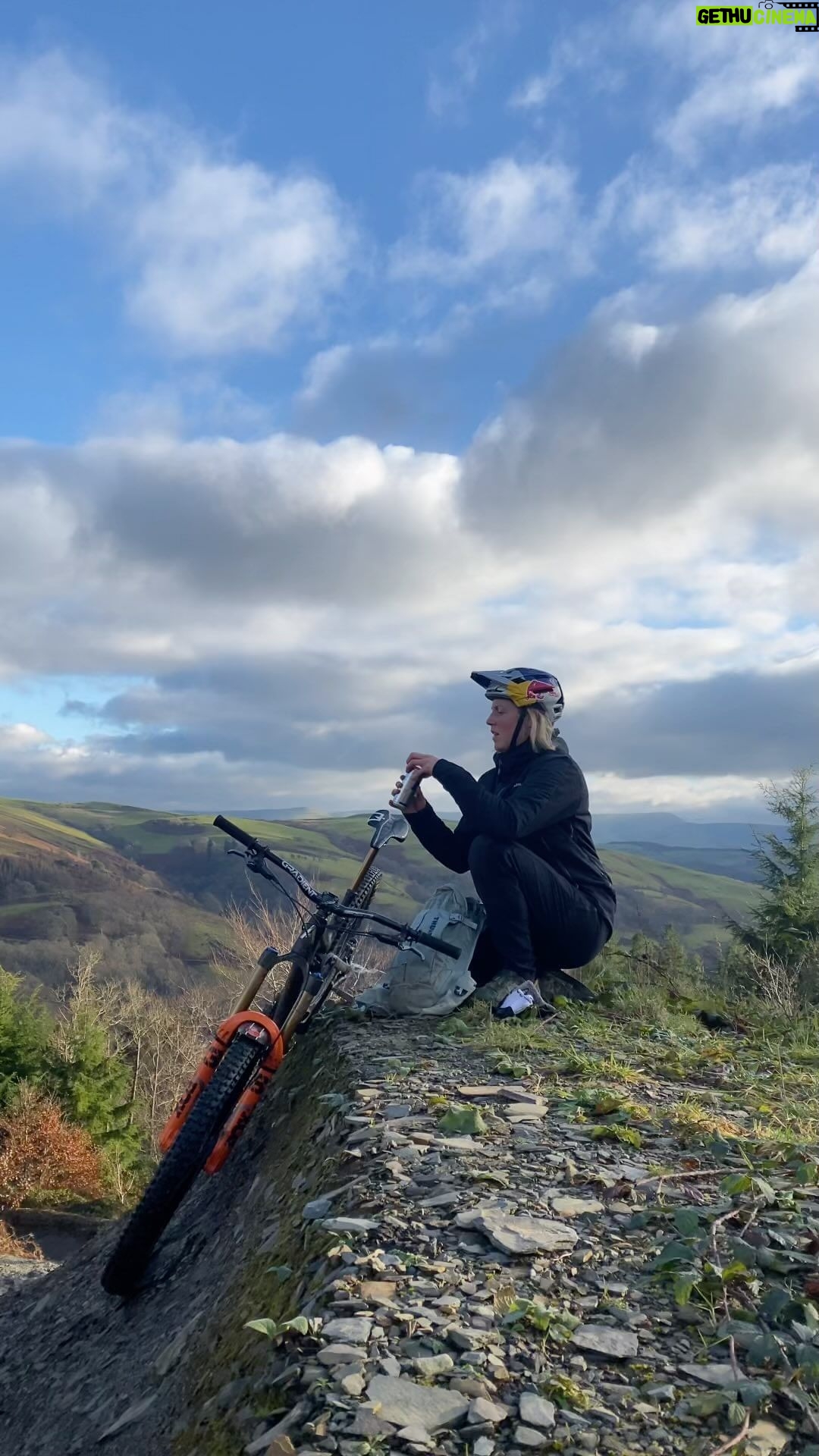 Rachel Atherton Instagram - Solo Adventures 🥰 but AM I A GENIUS ?! Have I discovered something new or does anyone else do this with their mid ride redbull?!! 🤯👌👌 Honestly I couldn’t believe I’ve never put my redbull in here for the climb 😂 instead of spending the whole climb holding it between brake lever and grip 😂 Anyway, last week I was trying to pedal some distance & I set off with good intentions, but when I pedalled past the jumps…. I literally spent the whole time just lapping the middle section of the @oakleybike Icon Way jumps @dyfibikepark 😂 It was so good just carving jumps solo & taking in this view on the climb back up 😍😍