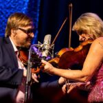 Rhonda Vincent Instagram - 🎧: @rhondavincent // @adamhaynes4 🎻🎻 📍: @industrialstrengthbluegrass 📸:l @xlacimack #rhondavincent #fiddle #twinfiddles #bluegrassmusic #pinkdress #marthawhite Industrial Strength Bluegrass