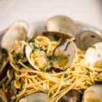 Stefano Faita Instagram - Spaghetti alle vongole 🤌🍝 Ingrédients • 1½ lb de palourdes fraîches • 1 paquet (454 g) de spaghetti Stefano • 60 ml (4 c. à table) d’huile d'olive extra vierge Stefano, divisée • 3 à 4 grosses gousses d’ail, émincées • 10 ml (2 c. à thé) de flocons de piment chili • ⅓ tasse (80 ml) de vin blanc sec • 45 ml (3 c. à table) de beurre non salé • Poignée de persil frais, haché • Sel et poivre fraîchement moulu, au goût Préparation 1. Placer les palourdes dans un grand bol d’eau froide et les laisser tremper 15 à 20 minutes pour déloger toutes traces de sable et d’impuretés. Rincer abondamment et réserver. 2. Porter une grande casserole d’eau salée à ébullition. Cuire les pâtes très al dente, environ 6 minutes. La cuisson se terminera dans la poêle. Réserver un peu d’eau de cuisson (au moins ¼ tasse) avant d’égoutter les pâtes. 3. Pendant ce temps, chauffer 3 c. à soupe (45 ml) de l’huile d’olive à feu moyen dans une grande poêle. Quand l’huile est chaude, ajouter l’ail et cuire jusqu’à ce qu’il soit tout juste doré, 1 à 2 minutes. Ajouter les flocons de piment chili et poursuivre la cuisson 15 à 30 secondes de plus. 4. Ajouter le vin blanc et faire mijoter. 5. Ajouter les palourdes nettoyées à la même poêle. Couvrir et cuire jusqu’à ce que les coquilles commencent à s’ouvrir (environ 3 à 6 minutes, dépendamment de la taille des palourdes). 6. À l’aide de pinces, retirer les palourdes ouvertes de la poêle. Réserver dans un bol séparé. 7. Verser environ ¼ tasse (60 ml) de l’eau de cuisson des pâtes dans la poêle et porter à ébullition. Ajouter les pâtes égouttées et cuire 1 minute en remuant constamment, jusqu’à ce que les pâtes soient al dente et qu’elles aient absorbé une partie du liquide contenu dans la poêle. 8. Remettre les palourdes cuites réservées et tout leur jus dans la poêle. Ajouter le persil et remuer soigneusement. Transférer dans une grande assiette de service ou dans des bols individuels. 9. Verser le reste de l’huile d’olive en filet et servir immédiatement. Buon appetito!