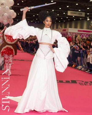 Tia Kofi Instagram - Drag Con UK Day One 👑
An incredible day I will always remember at @rupaulsdragcon! The new cast of Drag Race UK versus the World was officially announced. Swipe to see my reaction after the announcement 😇
Look by @mrmakonam 
Hair by @styledbyvodka 
Lightsaber by me rhinestoning for a week while watching Line of Duty on @bbciplayer 
#DragRace #DragRaceUK #ukvstheworld