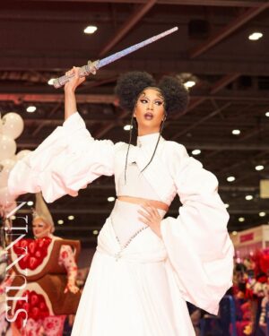 Tia Kofi Instagram - Drag Con UK Day One 👑
An incredible day I will always remember at @rupaulsdragcon! The new cast of Drag Race UK versus the World was officially announced. Swipe to see my reaction after the announcement 😇
Look by @mrmakonam 
Hair by @styledbyvodka 
Lightsaber by me rhinestoning for a week while watching Line of Duty on @bbciplayer 
#DragRace #DragRaceUK #ukvstheworld