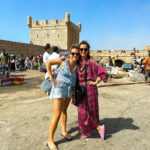 Vera Kolodzig Instagram - Dia 13: Conhecida como a “Cidade Ventosa de África”, Essaouira atrai muitos kitesurfers durante o ano inteiro, no entanto há muito mais do que o areal a perder de vista, ou o cenário do Game of Thrones. O sultão Mohammed Ben Abdallah instalou-se aqui no século XVIII e contratou um arquitecto francês para desenhar uma cidade no meio do vento e da areia onde nada existia antes. Originalmente chamada de Mogador, o sultão mudou o nome para Essaouira que significa “bem desenhado”, com a sua mistura única de estilo marroquino e europeu. Chegámos ontem à noite, já com mesa marcada num restaurante sugerido por um amigo, onde reencontrámos a amiga que fizemos em Tarifa na noite antes de iniciarmos a viagem. Acabámos num nightclub onde uma troca de olhares nos levou a conhecer os melhores guias que podíamos desejar. A manhã de hoje foi na praia, com um mergulho salgado para lavar a alma. Surgiu então a possibilidade de ir à lota comprar o marisco mais fresco que alguma vez vi. Ao passar o arco do kasbah parecia todo um novo mundo, com as embarcações já atracadas e dezenas de pessoas a vender o que pescaram de manhã, enquanto as crianças se atiravam dos muros da fortaleza para o mar. Foi neste momento que decidi que se há locais para abrir excepções à minha habitual dieta, este é um deles, ainda assim mantendo os meus princípios - saúde e sustentabilidade. Duas lagostas, um caranguejo, camarões e uma conserva caseira, por 500dhr negociados pelos nossos amigos marroquinos. Depois levaram-nos pelo labirinto da medina até um terraço onde apenas famílias locais se deliciavam. Entregámos as nossas compras, e uma hora depois tínhamos uma mesa repleta das mais incríveis iguarias, por mais 60dhr - o custo do “aluguer” de um espacinho na grelha. Uma experiência que ficará para sempre nas nossas memórias e nos nossos corações, já com uma pequena nostalgia de uma despedida para breve. Amanhã começamos a subir, de barriga cheia e inshallah sem caganeira! . . . #roadtrip #morocco #essaouira #localexperience #instatravel #seafood Essaouira - Mogador - الصويرة