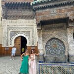 Vera Kolodzig Instagram - Dia 5: Tivemos algumas dúvidas sobre vir a Fes pelos comentários horrorizados dos nossos amigos em Portugal quanto às temperaturas em Marrocos em Agosto. Decidimos deixar o plano em aberto e deixar fluir, e assim que percebemos que as temperaturas são toleráveis, decidimos vir. Fes tem a maior Medina (cidade velha) do mundo árabe, com 220 hectares de ruas estreitas (9200 ao todo) e construções altas que garantem a sombra. Este labirinto caótico é a maior área urbana pedonal do mundo inteiro, onde casas, lojas, oficinas, escolas e palácios acolhem duas vezes mais habitantes do que Manhattan, e mesmo assim o ambiente é mais sereno e íntimo. Para visitar a Medina contámos com a ajuda de um guia que nos mostrou o bairro dos carpinteiros, o bairro dos alfaiates e alguns monumentos importantes como a Madrasa Bou Inania e o museu Nejjarine, um antigo “hotel de caravanas” onde os comerciantes deixavam os animais e mercadorias no centro rectângular para pernoitarem nos quartos nos andares de cima. Não podíamos deixar de passar na Chouara Tannery. Assim que entrámos tivemos de conter o vómito pelo cheiro nauseabundo que se faz sentir. Vimos todo o processo de lavagem e tintura das peles apenas por breves momentos, suficientes para o cheiro se entranhar até ao cérebro sem mesmo o molho menta que nos deram para a mão conseguir disfarçar. Nada que não ficasse esquecido com os pedidos que fizemos no mausoléu de Mulay Idriss, descendente directo do profeta Maomé. Oxalá se realizem os nossos desejos mais profundos! . . . #fes #morocco #instatravel #medina #fesmedina #travel