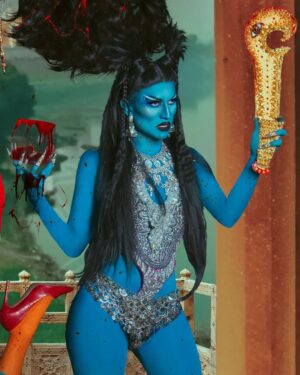 Vermelha Noir Instagram - 🩸 Chinnamasta 🩸
Es una diosa hindú que se representa desnuda auto-decapitada, normalmente en pie o sentada en una pareja divina copulando, sostiene su cabeza decapitada en una mano y una cimitarra en la otra. Tres chorros de sangre surgen de su cuello y son bebidos por la cabeza decapitada y dos asistentes.
Es la diosa de las contradicciones. Simboliza ambos aspectos de Devi: la que da y la que quita la vida. Es considerada tanto un símbolo de autocontrol sexual como una personificación de la energía sexual, dependiendo de la interpretación. Representa la muerte, la temporalidad y la destrucción así como la vida, la inmortalidad y la recreación. 

Para este trabajo en colaboración con @dankografia y @jesusteayude cuento con la presencia de ellos mismos como la pareja copulando y a mi hijo @bendeck_bendeck y @lvbnagaia cómo las entidades a los lados de la diosa.
.
Fotografía y dirección C
@dankografia @jesusteayude
Dress & heels: La presi y 
Makeup, headpiece & styling: Vermelha Noir
.
💄 PRODUCTOS 💄
⚪Base : Labial Rojo MAC Cruella
👁️ Ojos y contour : @jeffreestarcosmetics
⚫Delineador y cejas
@guerlain
🖤 Labios @naturalgirl
⬛ Enmarcado @bodypaintbykj
.
#fashion #drag #gay#art #makeup #lgbt #photograph #instagay #dragqueen #instadrag #dragrace#lgbtq #queen #dragmakeup #instagay #dragqueyensoyfinstagram #gayboy #dragqueenmakeup #fashion #fashiondesigner #makeupartist #style #art #localqueen #dragartist #red #secondhandclothing