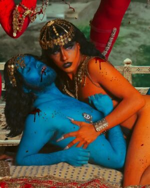 Vermelha Noir Instagram - 🩸 Chinnamasta 🩸
Es una diosa hindú que se representa desnuda auto-decapitada, normalmente en pie o sentada en una pareja divina copulando, sostiene su cabeza decapitada en una mano y una cimitarra en la otra. Tres chorros de sangre surgen de su cuello y son bebidos por la cabeza decapitada y dos asistentes.
Es la diosa de las contradicciones. Simboliza ambos aspectos de Devi: la que da y la que quita la vida. Es considerada tanto un símbolo de autocontrol sexual como una personificación de la energía sexual, dependiendo de la interpretación. Representa la muerte, la temporalidad y la destrucción así como la vida, la inmortalidad y la recreación. 

Para este trabajo en colaboración con @dankografia y @jesusteayude cuento con la presencia de ellos mismos como la pareja copulando y a mi hijo @bendeck_bendeck y @lvbnagaia cómo las entidades a los lados de la diosa.
.
Fotografía y dirección C
@dankografia @jesusteayude
Dress & heels: La presi y 
Makeup, headpiece & styling: Vermelha Noir
.
💄 PRODUCTOS 💄
⚪Base : Labial Rojo MAC Cruella
👁️ Ojos y contour : @jeffreestarcosmetics
⚫Delineador y cejas
@guerlain
🖤 Labios @naturalgirl
⬛ Enmarcado @bodypaintbykj
.
#fashion #drag #gay#art #makeup #lgbt #photograph #instagay #dragqueen #instadrag #dragrace#lgbtq #queen #dragmakeup #instagay #dragqueyensoyfinstagram #gayboy #dragqueenmakeup #fashion #fashiondesigner #makeupartist #style #art #localqueen #dragartist #red #secondhandclothing