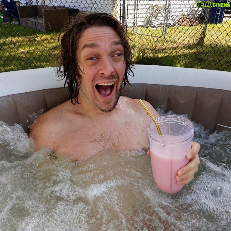 Zach Anner Instagram - My electric razor died in the middle of shaving so I decided to have a strawberry milkshake in the hot tub. Can anyone beat this Saturday? #Milkshake #Hottub # halfbeard #LiveYourBestLife