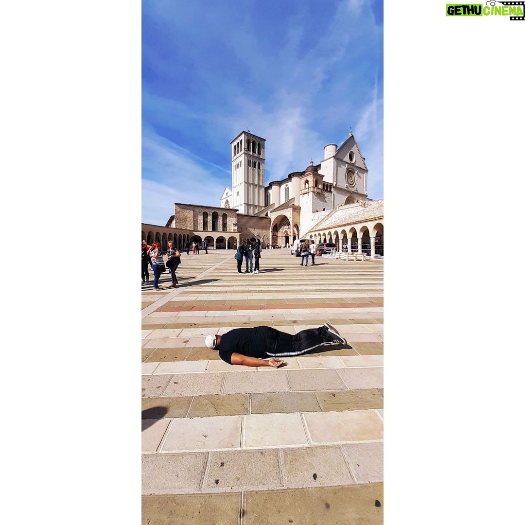 André Gabeh Instagram - Hoje é dia de SÃO FRANCISCO DE ASSIS e há quatro anos, em um Outubro luminoso e outonal da Itália estava eu, pobríssimo, mas cheio de pose, em Assis, terra de São Chiquinho o lindo amigo dos bichinhos. Lembram dessa viagem? Foi um presente de amigos maravilhosos e só pude estar lá graças a eles e às pessoas que contribuíram com um little cow que fiz pra não ir viajar sem dindin. Sou muito grato até hoje. Pobre? Sim. Mas na Itália. Deu tudo certo e meus amigos são tão generosos que vivi dias de realeza. Um brinde aos que alegram os outros intencionalmente. Lembro da paz desse lugar, da gentileza das pessoas, dos vendedores educadíssimos. De andar por lugares tão cheios de história. Desse céu de um azul em síntese. Da temperatura carinhosa. Passarinhos muito alheios a nossa mediocridade voavam por entre as mundanidades. Tudo lindo de fazer sorrir. Na foto minha performance mundial conhecida como #andrétombado #andretombado #andrétombadopelomundo Cliquem na hashtag e conheçam outras imagens. Que saudade de viajar pelo mundo. @luciobr te amarei para sempre. Assis, Italia