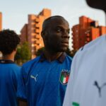 Antonio Dikele Distefano Instagram – ‘’Non esistono neri italiani’’. Me l’hanno detto molte volte, ma mai in faccia e mai con le parole. Me lo hanno detto con il loro corpo, con i loro sguardi, con la loro mimica, con le loro reazioni quando alla domanda ‘’dove sei nato?’’ rispondevo ‘’Busto Arsizio’’.
Lo capisci quando qualcuno pensa che non esistono neri italiani. Ti puoi convincere di essere forte, ma certe cose minano le tue sicurezze, a prescindere dal tuo carattere e dalla tua capacità di fregartene. Da piccolo non riuscivo a tifare l’Italia. ho pensato che io non potevo riconoscermi in quei giocatori, in quella divisa. 
Tutto cambiò con Balotelli. La semifinale e quella incredibile doppietta. Esultai come un folle, una gioia che non si spiega, come se qualcuno mi avesse liberato di un peso. Ma durò poco, mesi. Davanti allo schermo, circondato da colori azzurri, tra le gente  mi domando io chi sono, noi chi siamo. E anche qui sono le emozioni a darmi risposta. Il goal di Locatelli dopo una corsa di 60 metri, quello di sinistro da 20 metri e la mia reazione ad ogni goal. Le emozioni di quel momento mi dicono qualcosa. Parole che per anni non sono stato in grado di decifrare. Mi guardo intorno ed è bello sentire che vogliamo tutti la stessa cosa. Uscirne vincenti. 
Se voglio vincere non devo più lottare affinché gli altri lo accettino, perché non c’è nulla da accettare. Le cose cambiano quando sei tu, in primis, ad accertarti e a definire chi sei e a chiamarti con le giuste parole. Se vogliamo vincere dobbiamo credere alla voce dentro di noi e continuare a sognare. Io per esempio sogno un’Italia che non guardi più al passato, ma che abbia la forza di determinarsi nel presente e nel futuro. Nel futuro dell’Italia spero che i miei nipoti saranno più forti di me. Che a quegli sguardi che dicono che non esistono neri italiani riusciranno ad avere la forza e la lucidità di dire ‘’Non è vero. Io lo sono’’. 
Forza Italia. Andiamo a vincere.
@pumafootball 
#onlyseegreat #adv