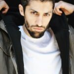 Azim Rizk Instagram - This is how I dramatically put on a hood. How’d I do? 😂 Shout out to the talented @kep.exe who makes me look badass no matter what I do! . . . . . . . . . . . #photography #bestphotographer #sweatshirt #sodramatic #mensfashion #middleeastern #iwanttoworkwith @missionworkshop #dudesinhoodies #curlyhair #menwithbeards #deathstare #intense