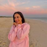 Beatriz Costa Instagram - 𝐎 𝐩𝐚í𝐬 𝐝𝐨 𝐬𝐨𝐧𝐡𝐨 𝐧𝐨 𝐫𝐞𝐠𝐚ç𝐨 𝐝𝐚 𝐦𝐨𝐫𝐞𝐧𝐚. Tenho escrito muito...este post foi quase a partilha de um texto, um desabafo sobre o mundo e o que me tem feito sentir nos últimos tempos. O silêncio nem sempre é sinal de indiferença, muitas vezes é sintoma de muita ação interna, muito pensamento e emoções que não conseguimos, por enquanto, traduzir em palavras. Resido na impotência de ver guerras, sofrimento, e não poder fazer nada para que acabe; e na alegria simples de poder ver um pôr do sol, como este, em segurança. Sentir-me segura, amada... Estar feliz e triste ao mesmo tempo. Que para estar só feliz teria que ser indiferente ao mundo, e isso não consigo...nem quero. Afinal as guerras não estão assim tão longe, às vezes até se sentam ao meu lado, que as pessoas também andam com batalhas internas, são guerras ambulantes algumas, só que fingem muito bem que estão bem. Somos todos tão diferentes e tão iguais, essencialmente. Queremos todos o mesmo: respeito, espaço para Ser, felicidade, segurança e amor. De todas estas coisas, o que poder dar a quem se cruza comigo, dou. Mesmo que não consigam fazer o mesmo comigo. Há uma linha que separa o amor do ódio: chama-se empatia. Escolho-a sempre que me é possível, e se não for (afinal sou só humana), distancio-me. O António Lobo Antunes escreveu muito melhor do que eu sobre o que estou a sentir, numa crónica que se chama "Juro que não vou esquecer". E diz assim "(..) Porquê ? que estúpido indignar-me, zango-me com Deus, comigo (...) gostava de ter os joelhos enormes de modo que coubessem no meu colo, em vez das cadeiras de plástico." Também gostava.