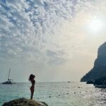 Beatriz Costa Instagram - Último post sobre a viagem que não é bem sobre a viagem. Temos uma sequência de fotografias em que parece que estou a ser abraçada pelo sol - ali a rasgar as nuvens para me agarrar; e depois temos uma das coisas que mais me impressionou no museu do vaticano: uma pintura do Dalí que mostra como a leveza e a alegria, quando dançam, deixam a angústia des-mai-ada (ela ali no canto a derreter numa pedra). É basicamente isso. Tudo neste post é sobre leveza e alegria, não vemos a angústia, porque ela estava fraquinha e decidiu não aparecer. A última (também numa das paredes do vaticano) parece-me um anjo a tentar mostrar a um mortal onde é que está a luz, mas ele não está a perceber nada, só olha para as asas. Achei bonito e ilustrativo. Mas se calhar sou só eu que estou a ver coisas. Beijo-vos anonas do deserto, boa noite 🤍 Italy