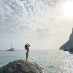 Beatriz Costa Instagram - Último post sobre a viagem que não é bem sobre a viagem. Temos uma sequência de fotografias em que parece que estou a ser abraçada pelo sol - ali a rasgar as nuvens para me agarrar; e depois temos uma das coisas que mais me impressionou no museu do vaticano: uma pintura do Dalí que mostra como a leveza e a alegria, quando dançam, deixam a angústia des-mai-ada (ela ali no canto a derreter numa pedra). É basicamente isso. Tudo neste post é sobre leveza e alegria, não vemos a angústia, porque ela estava fraquinha e decidiu não aparecer. A última (também numa das paredes do vaticano) parece-me um anjo a tentar mostrar a um mortal onde é que está a luz, mas ele não está a perceber nada, só olha para as asas. Achei bonito e ilustrativo. Mas se calhar sou só eu que estou a ver coisas. Beijo-vos anonas do deserto, boa noite 🤍 Italy