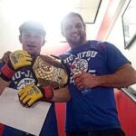 Brett Johns Instagram - 1 Decade ago! 21 year old me and John Phillips after winning the cage warriors world title on September 14th 2013. 2 Fights on one night. A total of 40 minutes of organised chaos that evening. What an experience, I’d never felt so many different emotions that day. I remember it like it was yesterday. Not many fighters get to call themselves world champions in this game. @cagewarriors @johnphillipsufc