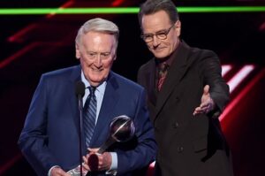 Bryan Cranston Instagram - A part of my childhood died yesterday. That may sound dramatic, and maybe it is, but it is how I’m feeling today. Los Angeles Dodgers’ legendary announcer, Vin Scully passed away at 94. What a brilliant life he led, and what an important part of my life he served. From the time I was able to understand what the radio was I would listen to Dodger baseball games. It was the beginning of a lifelong joy. Vin was never just about the score of the game. His stories made you feel like you were with him… like he was sharing a story just for you. As a child that was often a bedtime story, as I’d hide my transistor radio under my pillow to avoid parental detection. When times were tough, Vin was there to ease my pain or insecurities with the power of distraction. Because even if it was for only the next three hours, listening to Vin’s voice made me feel safe. Comforted. One of my greatest thrills was introducing Vin to my daughter, Taylor, at the ESPY’S in 2017, after I had presented Vin with the Icon Award. Taylor, an adult, and a catcher in her little league experience, nervously confessed to Vin that she listened to him her whole life… just like her dad.
His signature opening statement is indelible in my memory, “Hi everybody, and a very pleasant good evening to you, wherever you may be.” I’m here, Vin…I’m right here.