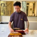 Cédric Grolet Instagram - Une bûche Chocolat pour Noël ! C’était juste obligatoire ! Alors on a travaillé sur l’origine du chocolat avec du chocolat 100% de Pérou sans sucre, une mousse chocolat légère au blanc d’œuf, du praliné cacao, un biscuit cacao, un crémeux cacao, des fèves gruées de cacao et tout ça sans gluten ! Disponible en édition limitée sur les dates du 21 au 26 décembre ! (Même le socle de la bûche se mange! ) #cedricgrolet 🖤 Cedric Grolet