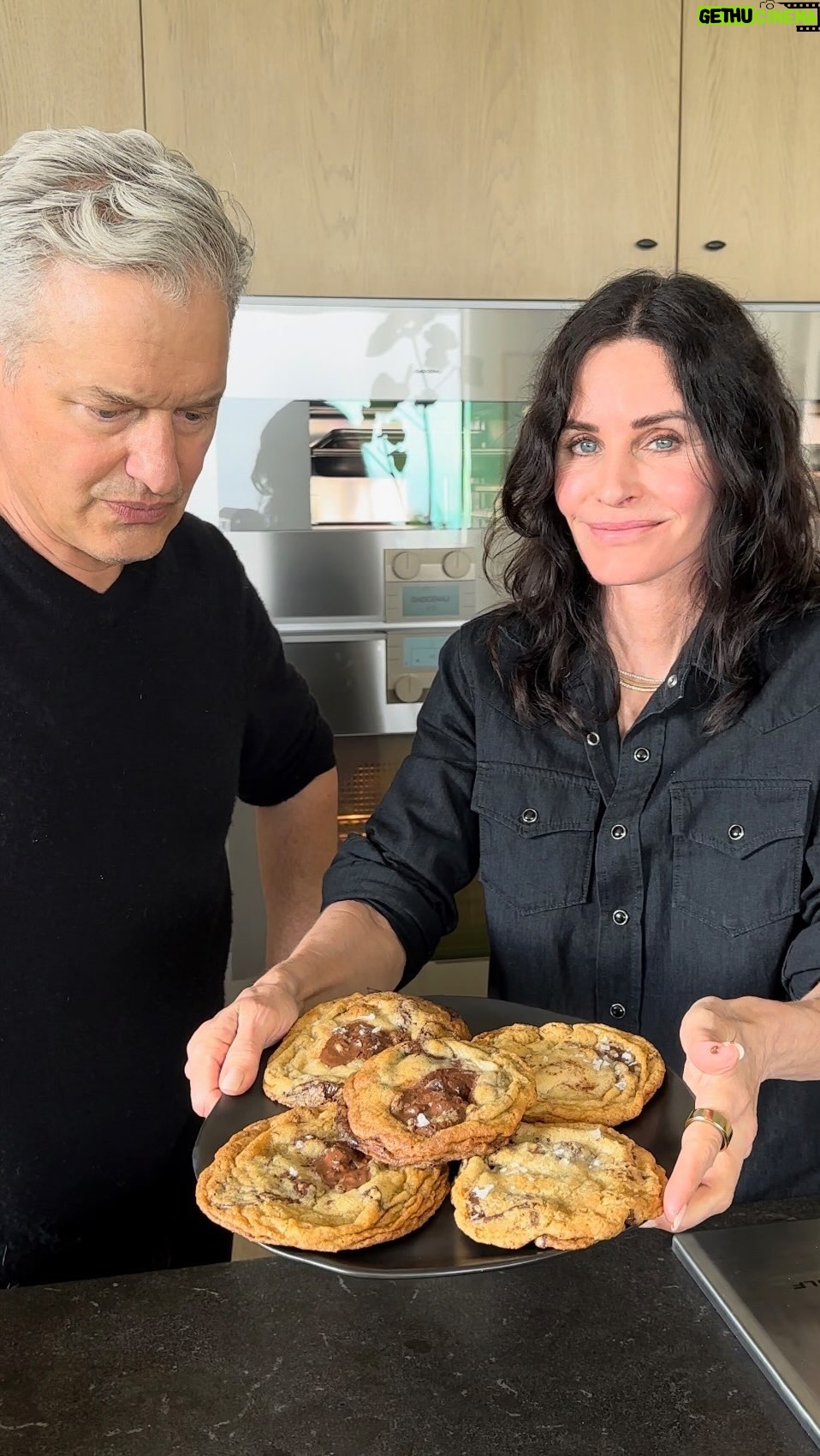 Courteney Cox Instagram - Seriously the best damn cookie I’ve ever had! CHOCOLATE CHUNK WITH MALDON SEA SALT 1 7/8 C CAKE FLOUR (8 1/2 oz) 1 2/3 C BREAD FLOUR 1 1/4 teaspoon BAKING SODA 1 1/2 teaspoons BAKING POWDER 1 1/2 teaspoons KOSHER SALT 1/8 teaspoon NUTMEG 1 1/4 C UNSALTED BUTTER (2 1/2 sticks) 1 1/4 C LIGHT BROWN SUGAR (10oz) 1 1/8 C WHITE SUGAR (8oz) 2 LARGE EGGS 2 teaspoons NATURAL VANILLA EXTRACT 2 C BITTERSWEET OR SEMI SWEET CHUNKS OR DISCS 3/4 C MILK CHOCOLATE CHUNKS CHOCOLATE FEVES OR LARGER 1” CHUNKS FROM A BAR MALDON SEA SALT All ingredients room temperature. Whisk the flours (or 4 C gluten-free flour if you wish) together with the baking soda, baking powder, kosher salt and nutmeg and set aside In the bowl of a stand mixer, beat the butter and sugars at high speed for at least 4 minutes Add the eggs and vanilla and beat for at least 2 more minutes Add the flour mixture and mix on the slowest speed JUST until combined. (If you see a little bit of flour left, that’s ok, finish mixing it with a wooden spoon. Mix the dark chocolate and the milk chocolate in a bowl Mix the chocolates into the dough with a wooden spoon or your hands Put the finished dough in a container or wrap in plastic wrap and refrigerate for 36-48 hours. Preheat oven 350 degrees. Line a large sheet pan with parchment. Take out dough, scoop into 4oz balls (about a 1/3 cup) Place the dough balls 2”-3” apart on the large parchment lined sheet pan. Do not crowd the pan…a 1/2 sheet pan can take about 4 cookies this size. Slightly press a larger chocolate chunk into the center of each dough ball. Bake on the center rack of the oven for 19 minutes…(there should be a mixture of golden brown and slightly darker light brown on the top of each cookie. Let cool on the sheet pan for at least 15 minutes and then transfer to a cooling rack to cool completely. When the cookies are cool but the chocolate is still glossy, sprinkle sparingly a few flakes of the Maldon Sea Salt.