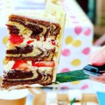 Courtney Ford Instagram - Proof of life. Proof of cake. 🎂: gluten-free chocolate/vanilla swirl cake, w/ german buttercream and strawberries inside, covered with white and dark chocolate “tree bark”, with a toasted mini marshmallow fire pit with strawberry fire 🍓 🔥 Paper cake topper decorations from @bonjourfete ✨