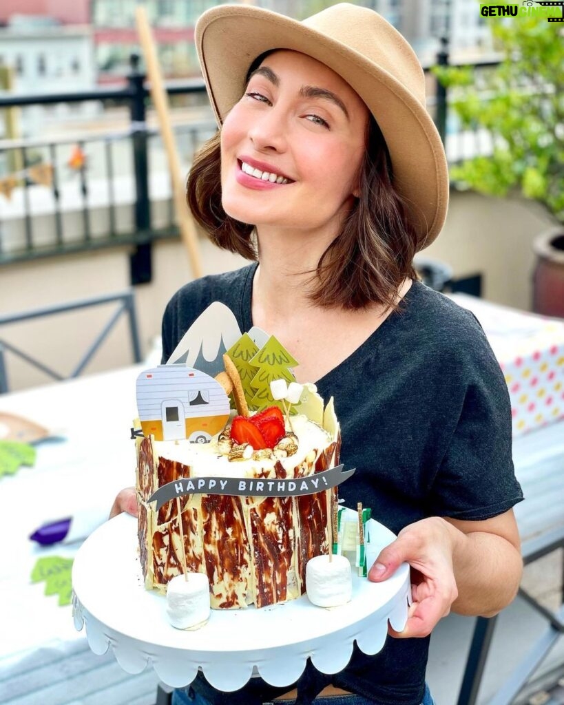 Courtney Ford Instagram - Proof of life. Proof of cake. 🎂: gluten-free chocolate/vanilla swirl cake, w/ german buttercream and strawberries inside, covered with white and dark chocolate “tree bark”, with a toasted mini marshmallow fire pit with strawberry fire 🍓 🔥 Paper cake topper decorations from @bonjourfete ✨