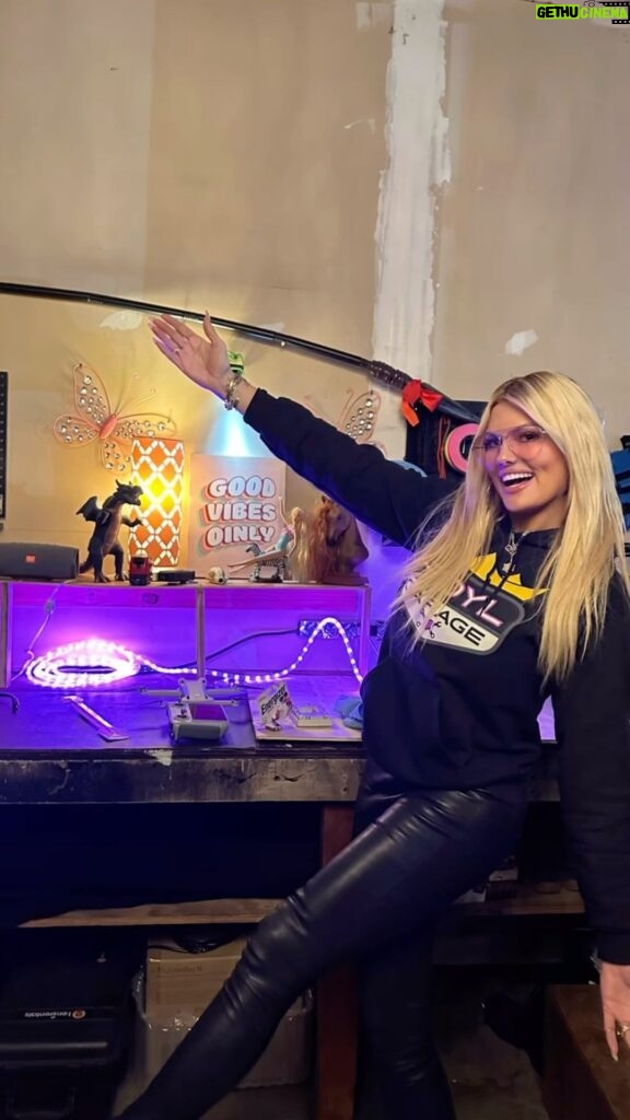 Courtney Hansen Instagram - Mimicking Barbie’s pose. Our camera crew created their space & incorporated my motto. Love it!!! And how badass is Bryan’s design area? This is only a little part of #ROYLGarage #goodvibesonly 💜