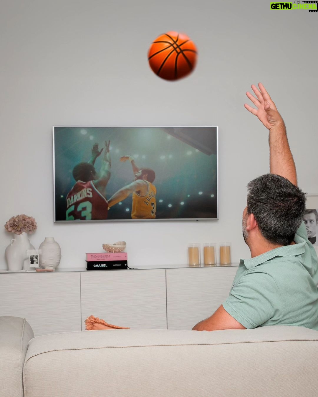 Diogo Beja Instagram - Quando era miúdo e jogava basket em Santarém, passávamos os intervalos a jogar e até nos corredores fazíamos uma espécie de "air basket" - driblávamos, lançávamos e até fazíamos bloqueios uns aos outros.. tudo sem bola. 🙈😁 Agora, com a chegada da segunda temporada de "Winning Time - The Rise of the Lakers Dynasty" isso voltou tudo! Imito o "gancho" do Kareem Abdul-Jabbar em todo o lado. É tão exagerado que até pedi à IA para colocar uma bola de basket a voar na nossa sala - a Mia ia adorar se isso acontecesse mesmo! 😁 Nestas férias, vou levar este meu "vício" comigo. Não o lançamento em gancho, mas a série. 😊 E para todo o lado, com a HBO Max. #HBOMax #WinningTime #HBOMaxPortugal #KareemAbdulJabbarWannaBe