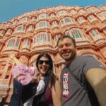 Eftyhis Bletsas Instagram - Αυτό το Σάββατο ξεκινάμε το roadtrip για να εξερευνήσουμε το λεγόμενο "Χρυσό Τρίγωνο" της Ινδίας. Πρώτος σταθμός η εντυπωσιακή Τζαιπούρ, γνωστή και ως ροζ πόλη χαρη στο χαρακτηριστικό χρώμα των κτιρίων της. Αυτό πίσω μας είναι το "παλάτι του αέρα", με τα 953 παράθυρα! Happy Traveller στην Ινδία μερος 2! Αυτό το Σάββατο στις 17:45 στον ΣΚΑΙ. Το @cosmoramatravel εχει μια τζετ οργανωμένη εκδρομή Ινδια για τις γιορτές. Jaipur, Rajasthan