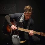 Eric Osmond Instagram - Throwback to some amazing memories with @raskguitars and the gang! 😍🎸 Their craftsmanship and innovation in creating unique guitars, using ancient materials, is truly awe-inspiring. The sound that resonates from their guitars is unparalleled and unlike anything you may have heard before! 🔥 I'm still blown away by the phenomenal sound and quality. If you're a music lover or a guitar enthusiast, you definitely need to check out @raskguitars to experience for yourself the magic they create. Can't wait to see what they come up with next! 🤩🎵 🎸 💡 Crazy idea... what if Robert were to let me use a Rask Guitar to record an acoustic version of my new song "Begin Again" (coming out on April 21st)! What do you think? Should I reach out to Robert Rask and see if we can make this happen? 😉 Fun Fact: When I first picked up a guitar, my very first jig was fiddling around on the high E string and trying to sound out the iconic theme song for Top Gun  ("Top Gun Anthem" by @haroldfaltermeyer) lol I'm sure you can hum it right now without even hearing it, it's that iconic. 🎶😄 Music seems to leave a unique memory, so when you hear an old song an entire of your life can emerge in moments for you. What song(s) do that for you? Do they make you want to... "Begin Again"?  💪🎶😁😉 #uniqueguitar #ericosmondmusic #newmusic #acousticguitar Rask Guitars