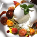 Hümeyra Aydoğdu Instagram - Tase fesleğenler 🌿 ve Sızma zeytinyağının en güzel birleşimi Pesto sos üzerinde Kiraz domatesler 🍅 ve Kremamsı dokusuyla Burrata peyniri 😍 yaz sofralarının vazgeçilmezi 🎉 #BURRATA 🤍 İtalyanca’da tereyağı anlamına gelen #burro kelimesinden türeyen Burrata peyniri, lezzetiyle tüm dünyada adını duyuran bir taze peynir çeşididir. Ve #İtalya ‘nın en sevdiğim bölgelerinden biri olan #puglia da 1920 yılında üretilmeye başlanmıştır 😍 #cheeselover #heal Ege