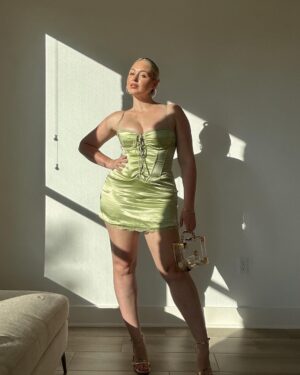 Iskra Lawrence Instagram - Mama is off to Miami this weekend for a bachelorette with 16 baddies… it’s about to be carnage🥵 until 11pm because - bedtime. so it’ll be sensible carnage and lots of reading books on the beach🫠

Photo description #accessibility : [Iskra is statuesque standing against her wall with golden hour sunlight pouring through the windows on her glowing skin. Wearing a mint green satin mini dress, with a clear gold Perspex handbag and gold strappy stiletto heels embodying the slayage]