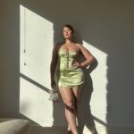 Iskra Lawrence Instagram - Mama is off to Miami this weekend for a bachelorette with 16 baddies… it’s about to be carnage🥵 until 11pm because - bedtime. so it’ll be sensible carnage and lots of reading books on the beach🫠 Photo description #accessibility : [Iskra is statuesque standing against her wall with golden hour sunlight pouring through the windows on her glowing skin. Wearing a mint green satin mini dress, with a clear gold Perspex handbag and gold strappy stiletto heels embodying the slayage] Miami, Florida