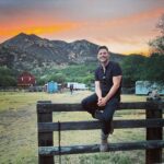 Jake Helgren Instagram - You can take the boy outta the country… But you can’t keep him from country summer sunsets & climbing fences (or 4 story-high windmills haha). Scroll => for 40 feet above action! . . . #directorlife🎬🎥 #ninthhousefilms #throwbackthursday Rancho San Cayetano