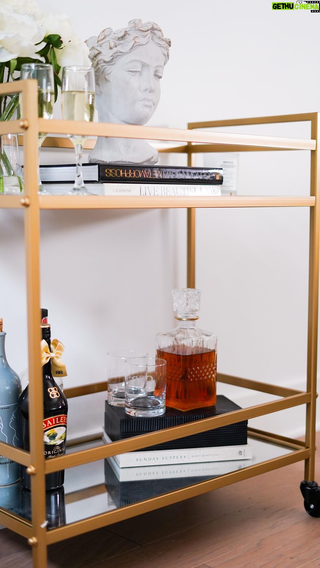 Jasmine Davis Instagram - The hubby and I are trying to spend less money out grabbing a drink and more time saying “aht aht” we got drinks at home. This @ashleyofficial bar cart fits our aesthetic perfectly and provides just the right amount of space for his “spirit’s collection”. Nestled flawlessly in our living room, the bar cart completes our space and makes hosting a breeze. #myashleyhome #ashleypartner