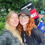 Jes Macallan Instagram - Literally, four weeks postpartum, to the day, @mrnicbishop and I had our first big outing away from baby. We chose to join our beloved friends and colleagues (also supported by our amazing “fanmily” with an ice cream truck 🤯, thank you from the bottom of my, just had a baby, heart). I had so much love in my body that day because it was also a mini reunion with so many people I love so hard, from a project that has meant so much to me for so long. At eight weeks postpartum, we took our little man for his first big outing to meet some more tv family that I love dearly and hold close to my heart. Here we are today… officially on strike. We stand by @sagaftra and our sister unions as a family. The future is… well, unclear. Warner Brother Studios