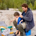 Jim Baird Instagram - New video up! (Link in bio.). In this one, @torigoesoutside and I continue down Northern BC’s Stikine River towards Alaska with our family. We camp in a couple nice places where we need to put our tarp to good use because of the rain. Breaking camp in the morning takes a lot more time with kids as they need to be fed and dressed, (you can see me putting on Wesley’s wet suit on in one of the pics here). Both adults can’t really work at camp tasks at the same time because one of us needs to keep a watchful eye on our son Hudson who likes to go for hikes (with or without us!). Things get more challenging when we’re traveling down river and the rain really picks up…it just won’t let up for hours and hours on end and we’re soaked. Come evening, we begin searching for a cabin that should be close by. Our river notes are 30 years old so we don’t really know if it’s even there anymore. Soaked to the bone, at this point we’d be very grateful for a place to get warm and dry out tons of wet cloths. Do we find it? #alaska #jbadventurer #stikineriver #canoetrip #familycamping #outdoors #campwithkids #wilderness